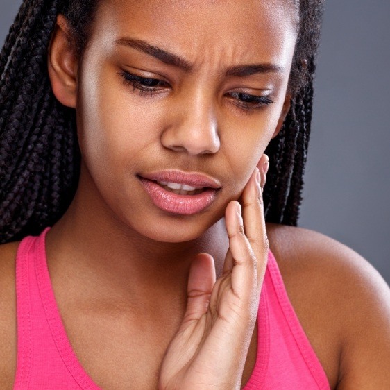 Woman in need of emergency dentistry holding jaw in pain