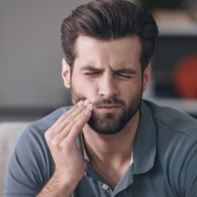 Man with toothache holding jaw