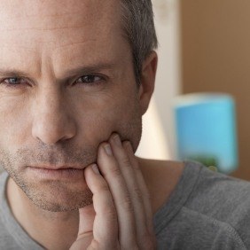 Man with chipped tooth holding jaw