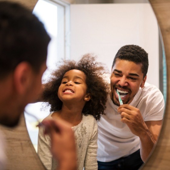 Father and child brushing teeth to prevent dental emergencies