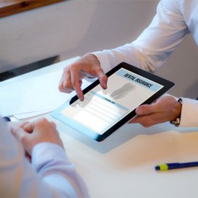 Two people using tablet to discuss dental insurance benefits