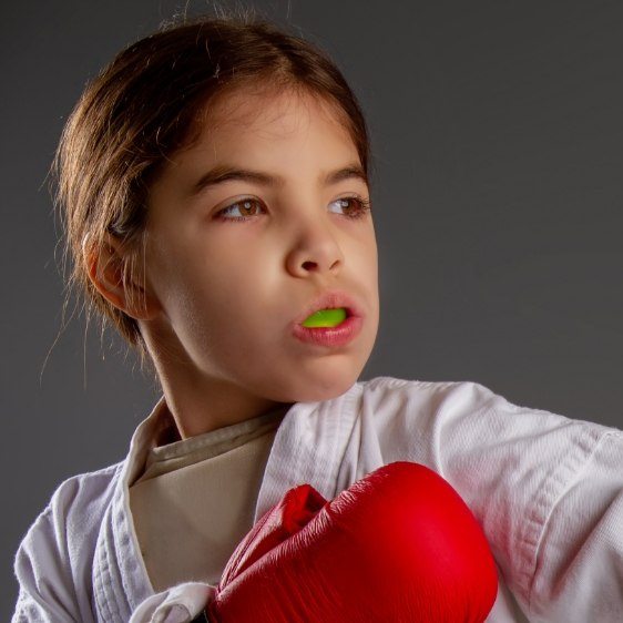 Young dental patient with green athletic mouthguard