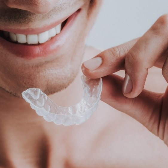 Closeup of dental patient placing nightguard for teeth grinding