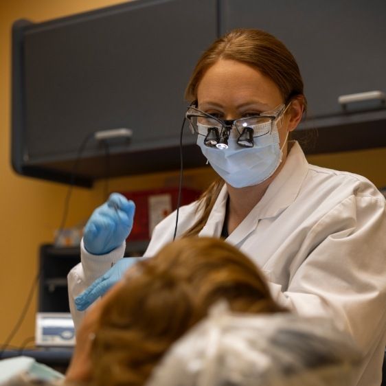 Dentist performing oral cancer screening