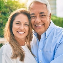 Man and woman with healthy smiles after replacing missing teeth