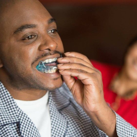 Man placing oral appliance for sleep apnea